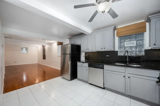 a kitchen with a sink a refrigerator and cabinets