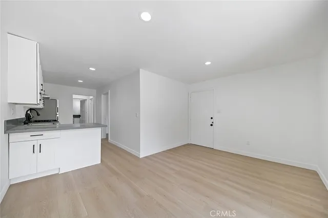 a view of a kitchen with cabinets and wooden floor