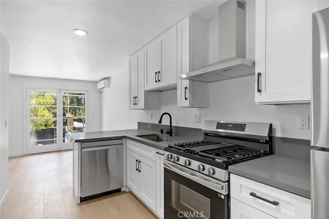 a white kitchen with granite countertop stainless steel appliances