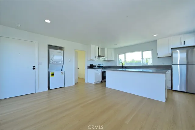 a kitchen with stainless steel appliances a refrigerator and a stove top oven