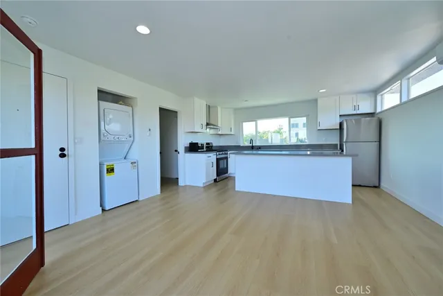 a large kitchen with a refrigerator and a stove top oven