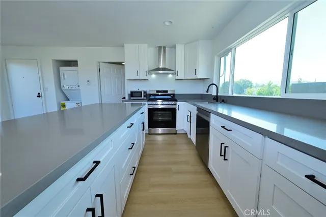 a large kitchen with stainless steel appliances granite countertop lots of counter space and a sink