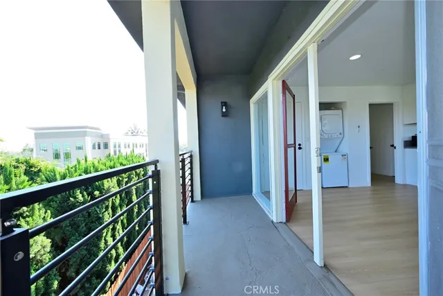 a view of a hallway with wooden floor and a bathroom