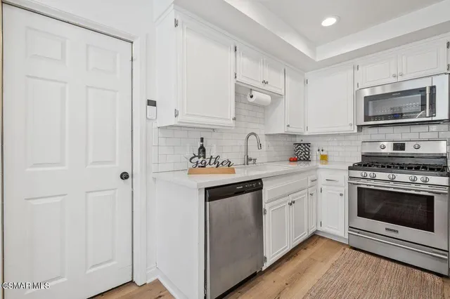 a kitchen with cabinets stainless steel appliances and a sink
