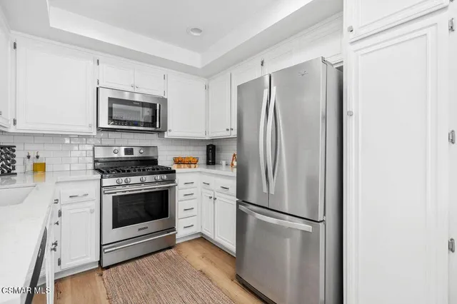 a kitchen with stainless steel appliances a refrigerator stove and microwave