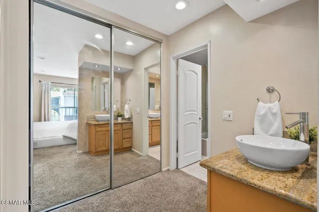 a bathroom with a granite countertop sink a toilet and a mirror