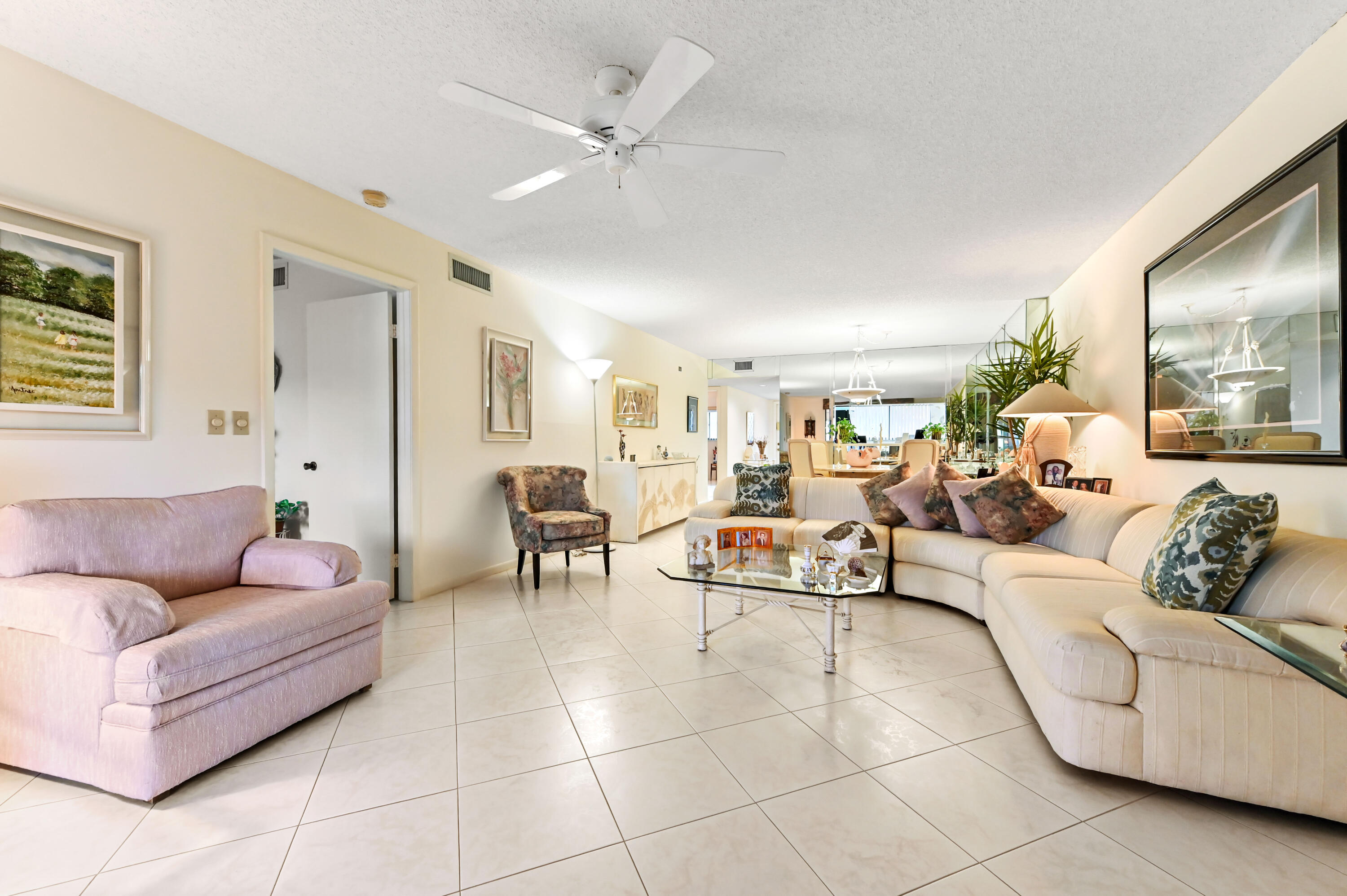 15074 Witney Road, Unit 107 Delray Beach, FL 33484 - Photo 13 of 60 a living room with furniture and a chandelier