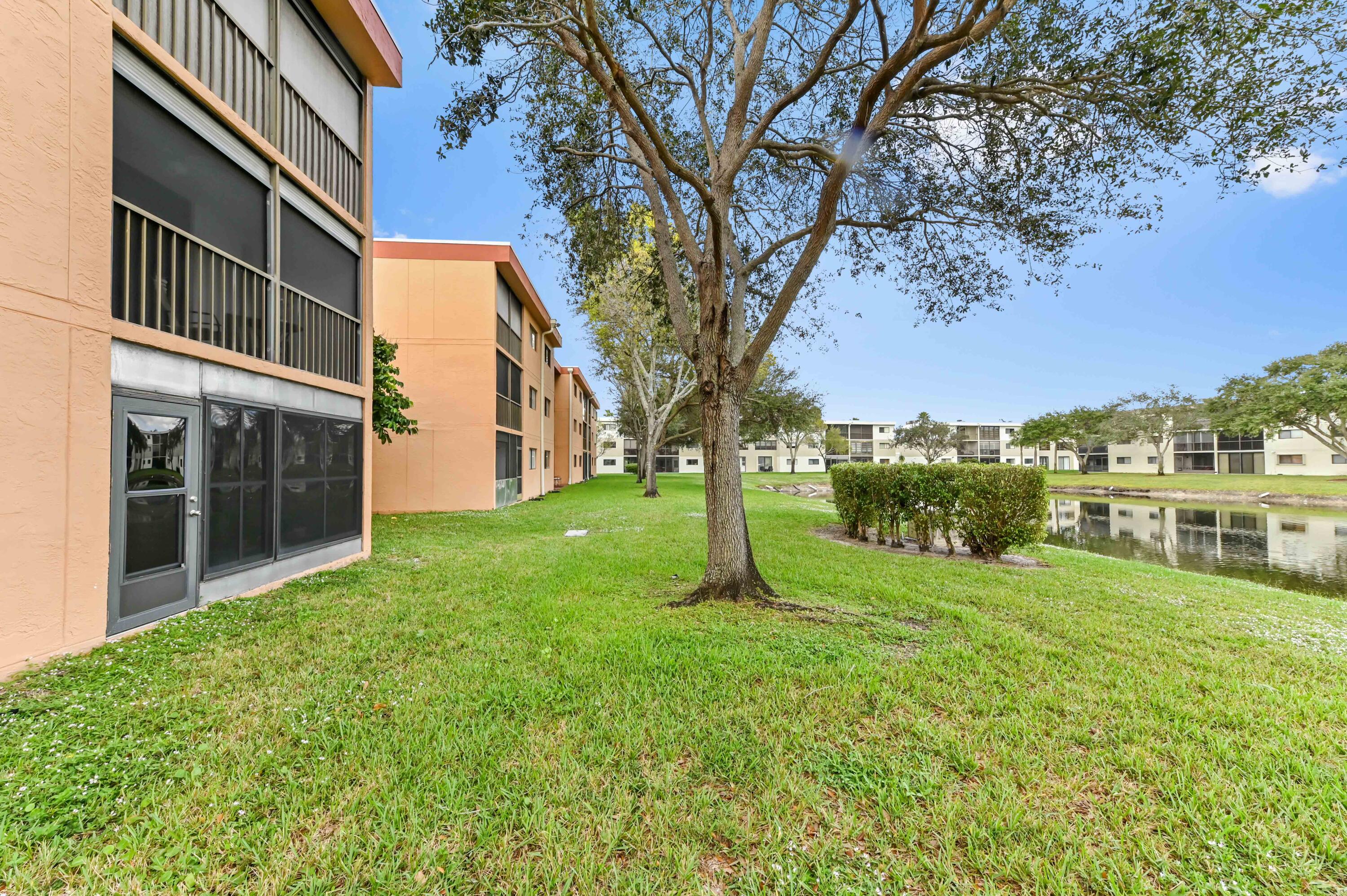 15074 Witney Road, Unit 107 Delray Beach, FL 33484 - Photo 25 of 60 a view of a house with a yard and a large tree