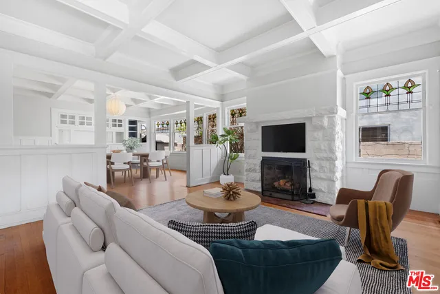 an empty room with windows a fireplace and wooden floor