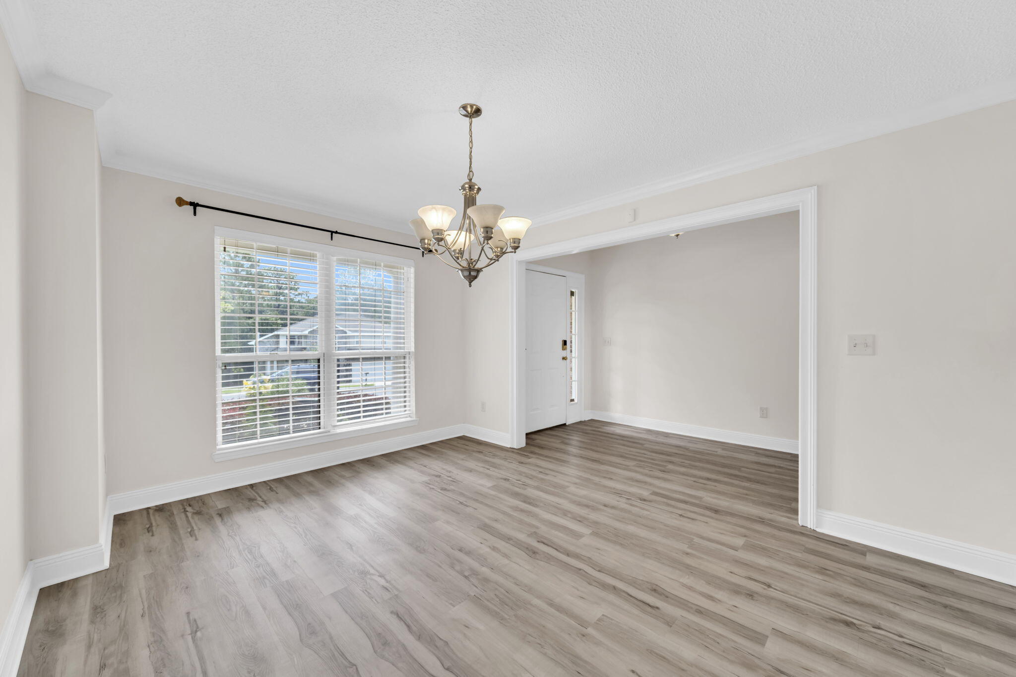 202 Gracie Lane Niceville, FL 32578 - Photo 12 of 47 a view of an empty room with wooden floor and a window