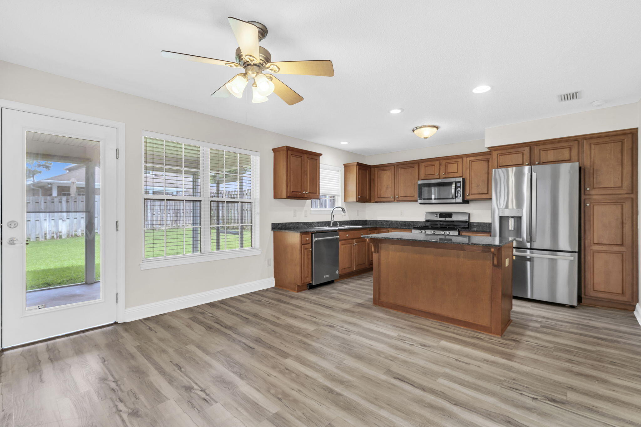 202 Gracie Lane Niceville, FL 32578 - Photo 19 of 47 a kitchen with stainless steel appliances a stove a refrigerator a sink a microwave oven with cabinets and wooden floor