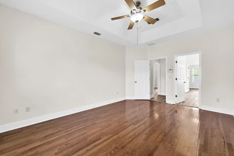a view of an empty room with wooden floor