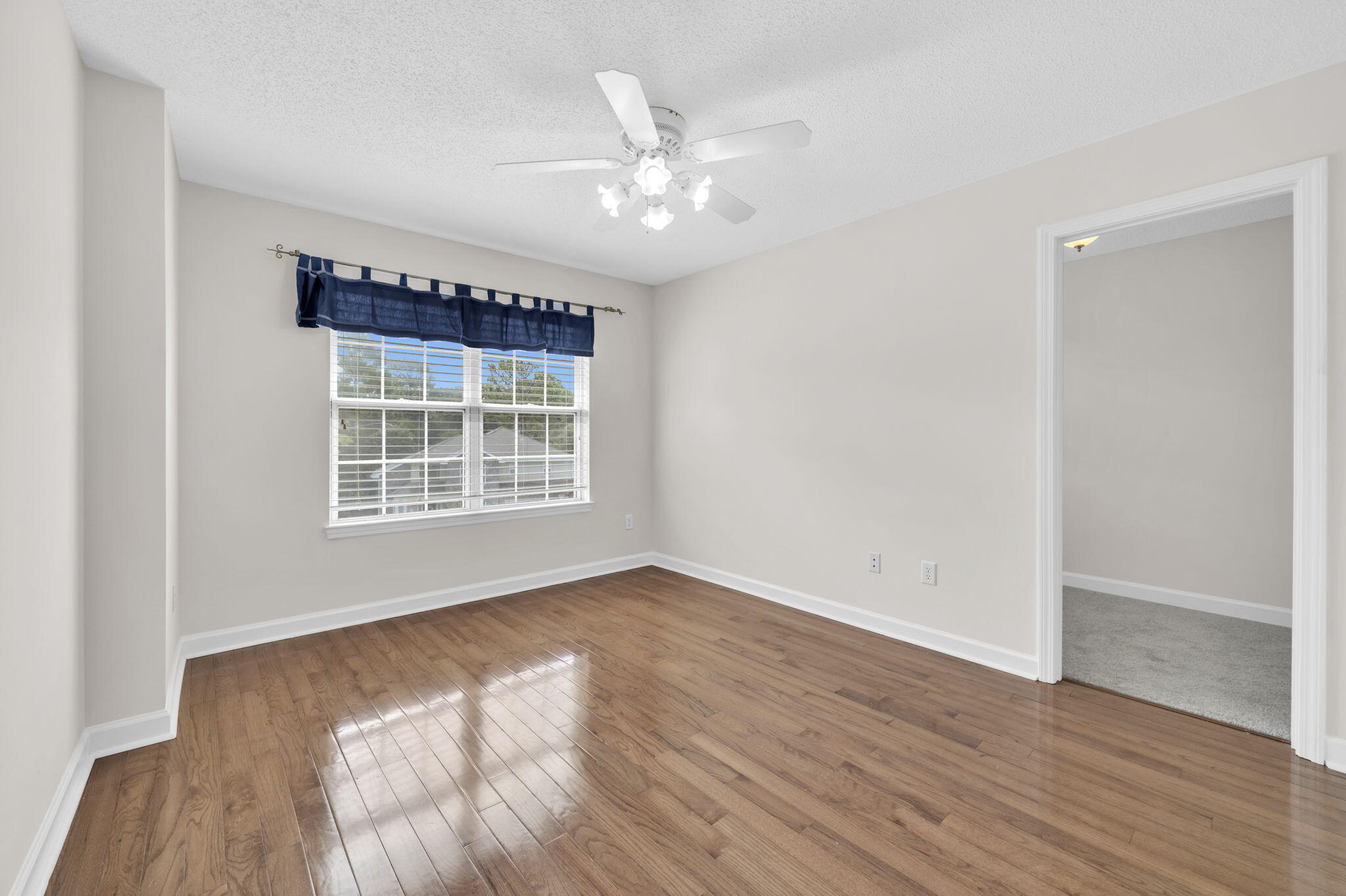 202 Gracie Lane Niceville, FL 32578 - Photo 33 of 47 a view of an empty room with wooden floor and a window