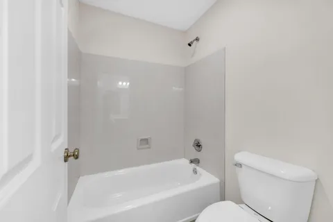 a bathroom with a toilet and bathtub