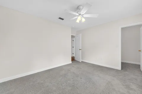 an empty room with a chandelier fan