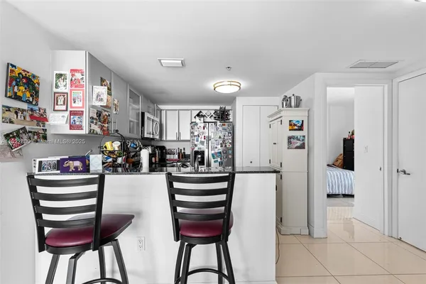 a kitchen with stainless steel appliances kitchen island granite countertop a refrigerator and cabinets