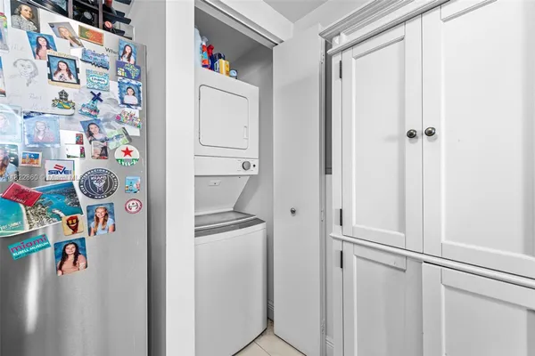 a utility room with fridge and rack