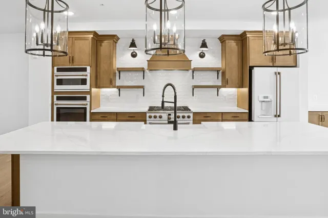 a view of a kitchen with stainless steel appliances granite countertop a sink dishwasher and a stove with wooden floor