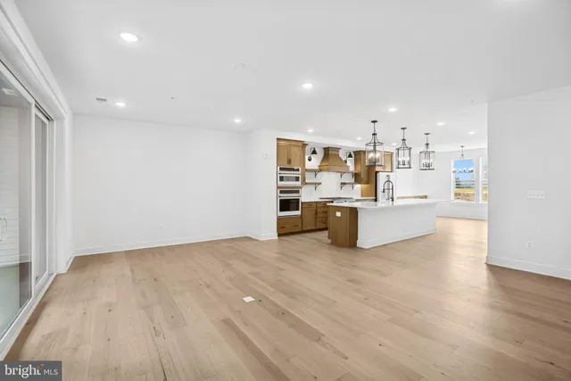 a view of a kitchen with wooden floor and windows