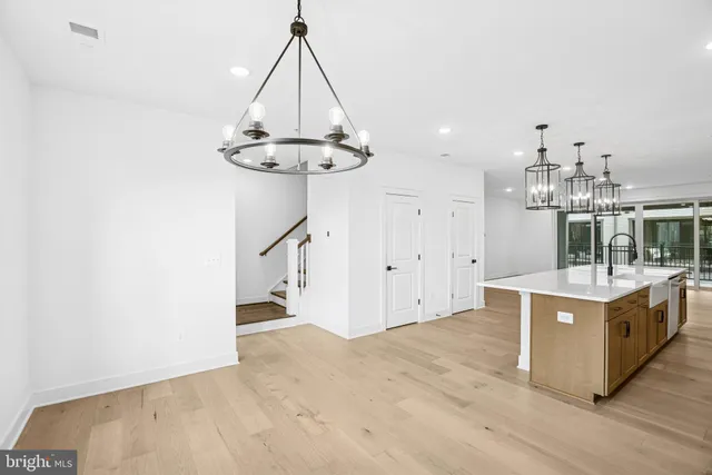 a view of a kitchen with stainless steel appliances granite countertop a sink a stove a refrigerator and island