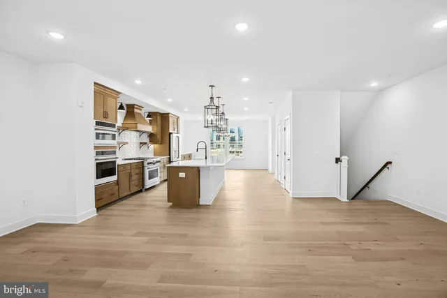 a view of kitchen and kitchen with stainless steel appliances wooden floor