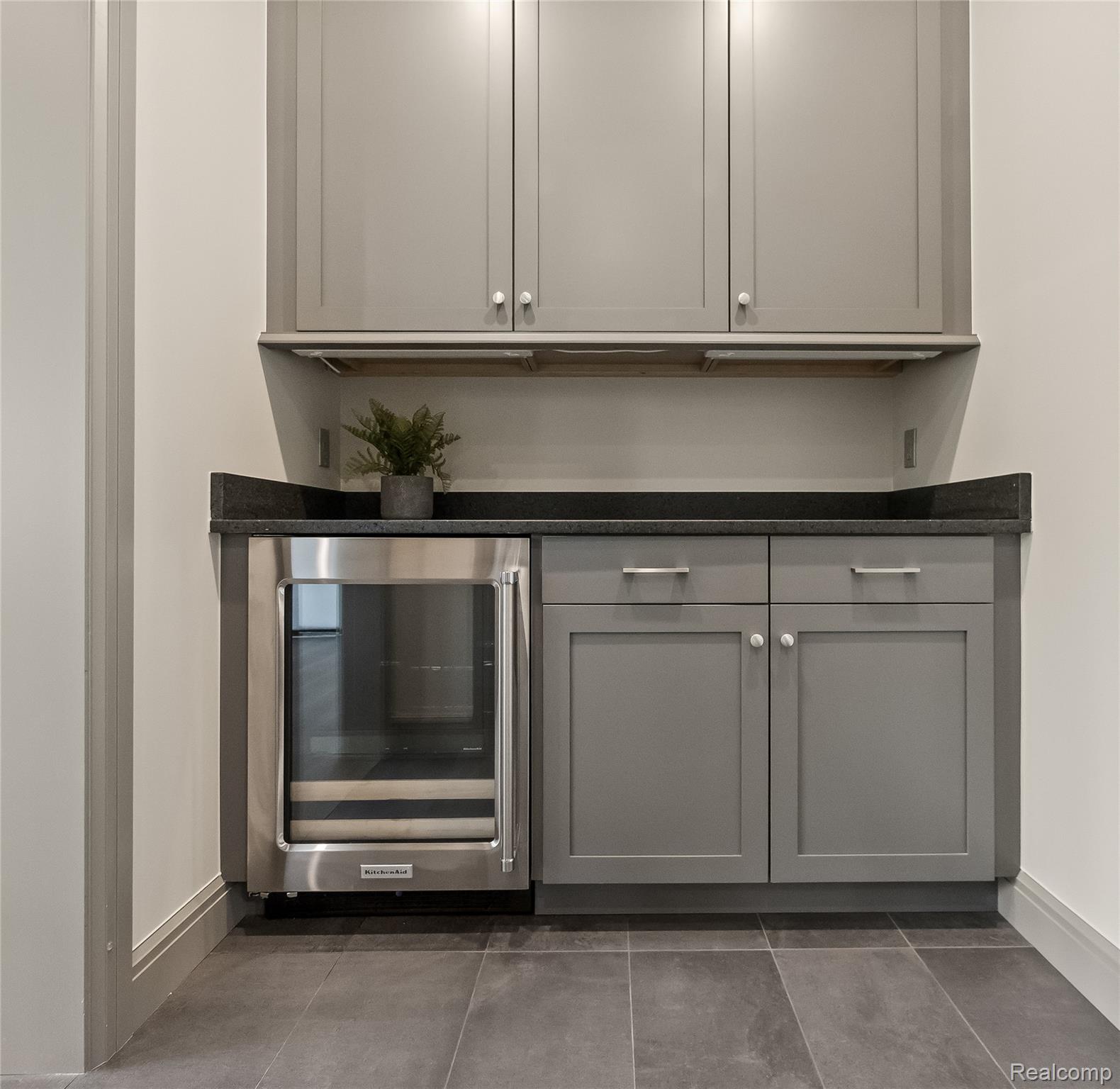 3824 Poppleton Street Troy, MI 48084 - Photo 16 of 51 Bar with gray cabinetry, beverage cooler, dark stone countertops, and dark tile patterned floors