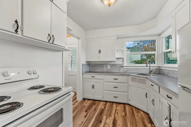 a kitchen with granite countertop white cabinets and white appliances