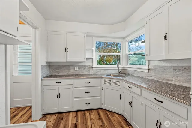 a kitchen with cabinets appliances and a window