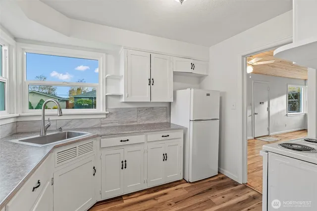 a kitchen with white cabinets and white appliances