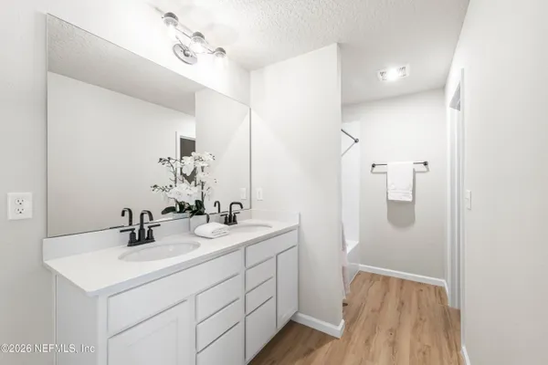 a bathroom with a sink a mirror a vanity and shower