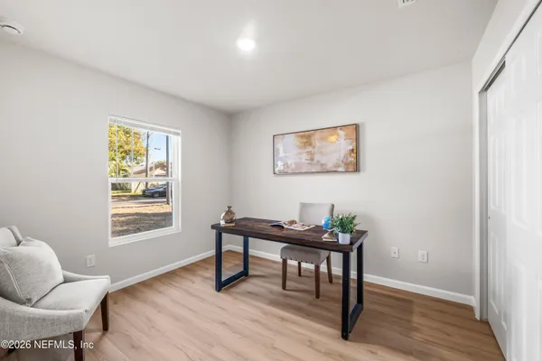 a view of a workspace with furniture and a window