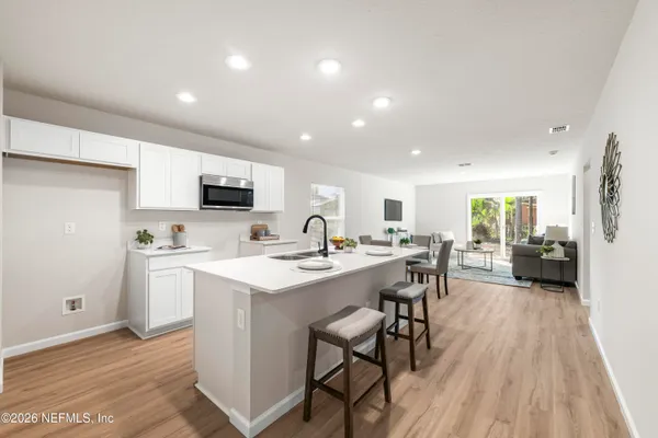 a kitchen with a sink stainless steel appliances and white cabinets