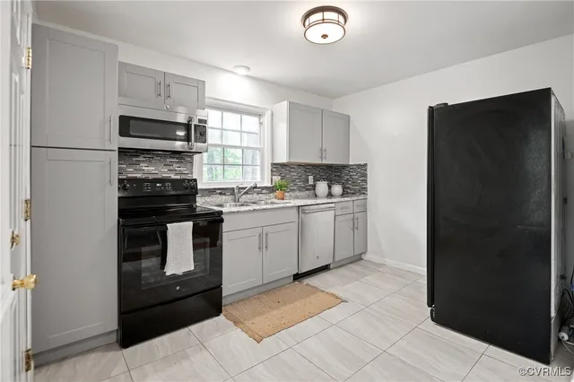 a kitchen with a sink a counter top space cabinets and stainless steel appliances