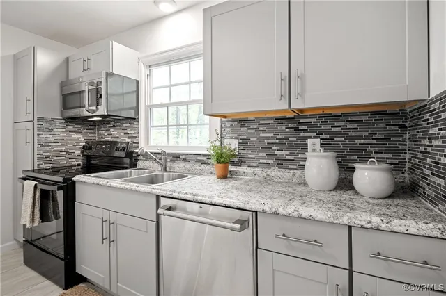 a kitchen with sink a stove and cabinets