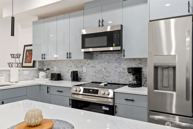 a kitchen with stainless steel appliances a refrigerator stove and microwave