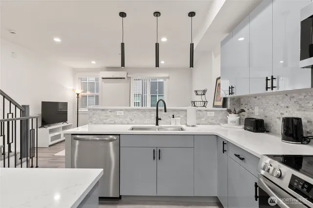 a kitchen with a sink a stove a kitchen island and chairs with wooden floor