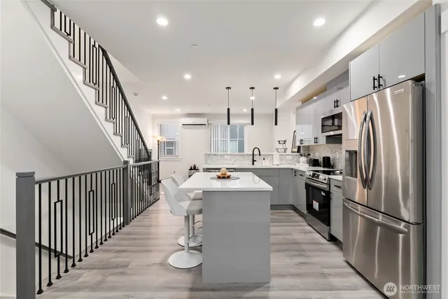 a kitchen that has a sink a stove and chairs in it