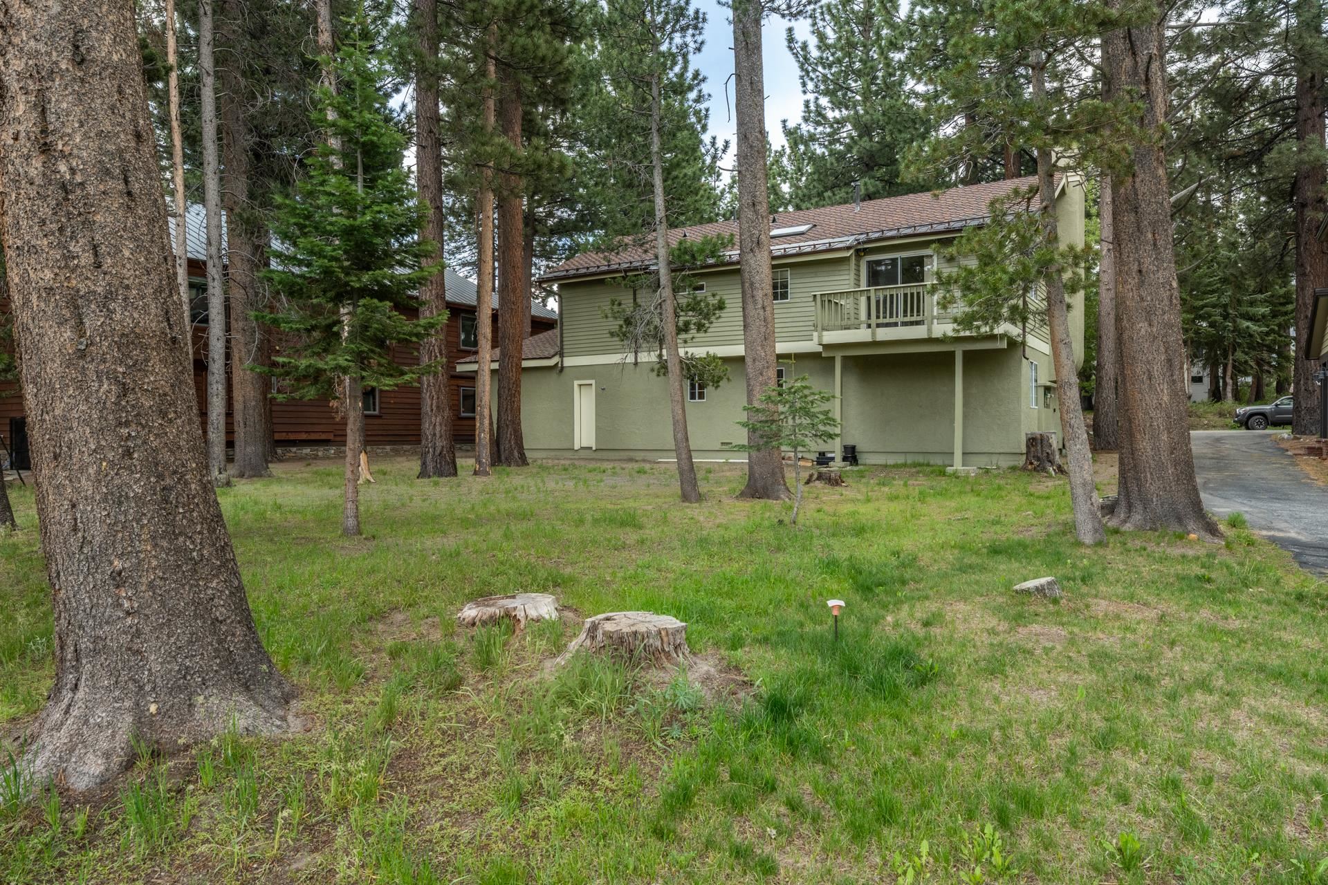 272 Ridge Way Mammoth Lakes, CA 93546 - Photo 50 of 55 Two-story property with a sage green exterior, featuring an upper-level balcony with wood railing, a brown shingle roof, and multiple windows