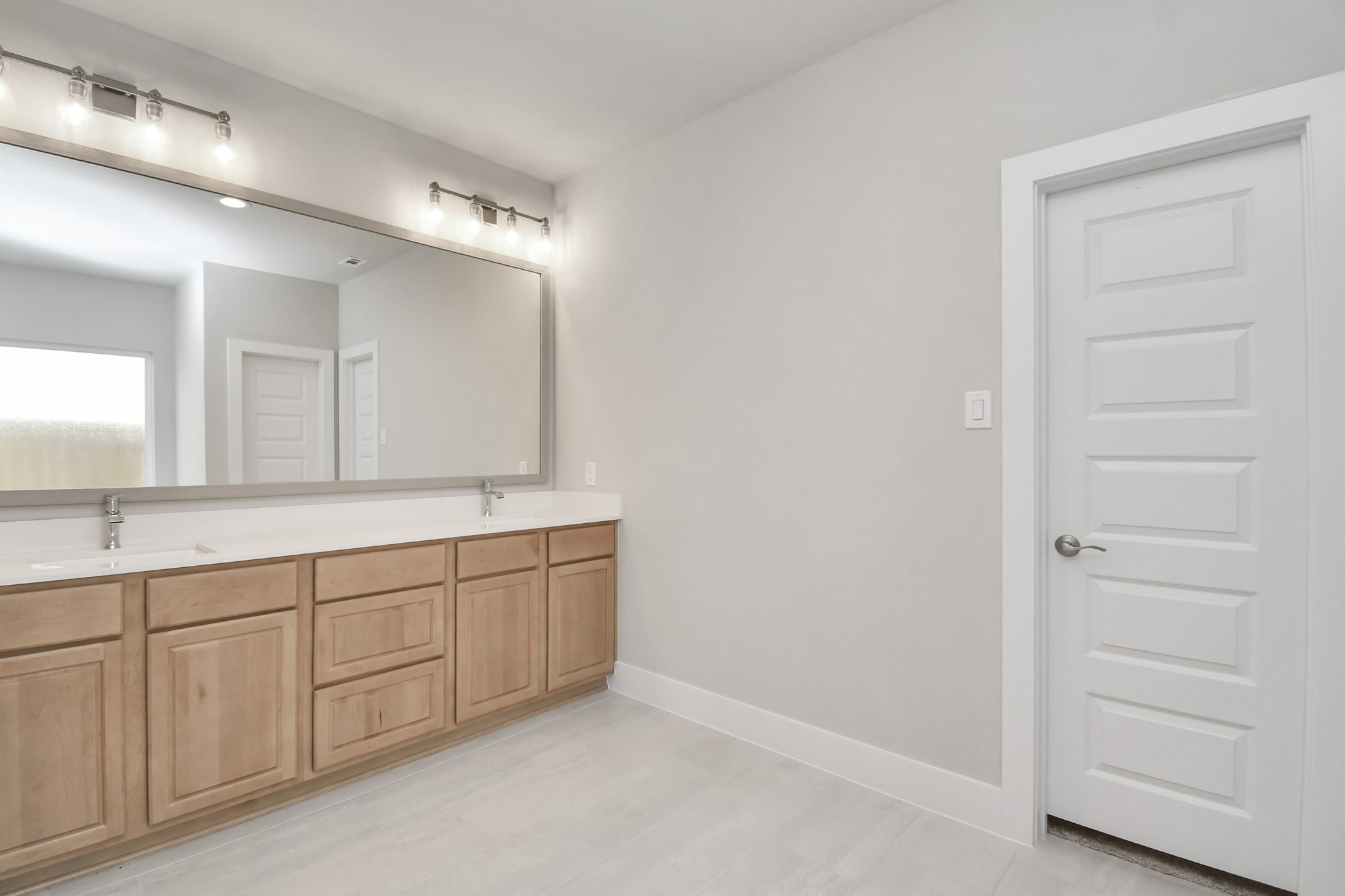 3038 Native Spg Drive Spring, TX 77373 - Photo 25 of 40 Elevate your daily routine at the elegant vanity, now equipped with double sinks, light countertops, modern hardware, and beautiful vanity lights. Sample photo of completed home with similar floor plan. Actual colors and selections may vary.