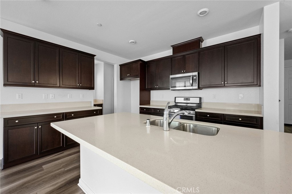 893 Harvest Avenue Upland, CA 91786 - Photo 4 of 40 a kitchen with stainless steel appliances granite countertop a sink stove and microwave
