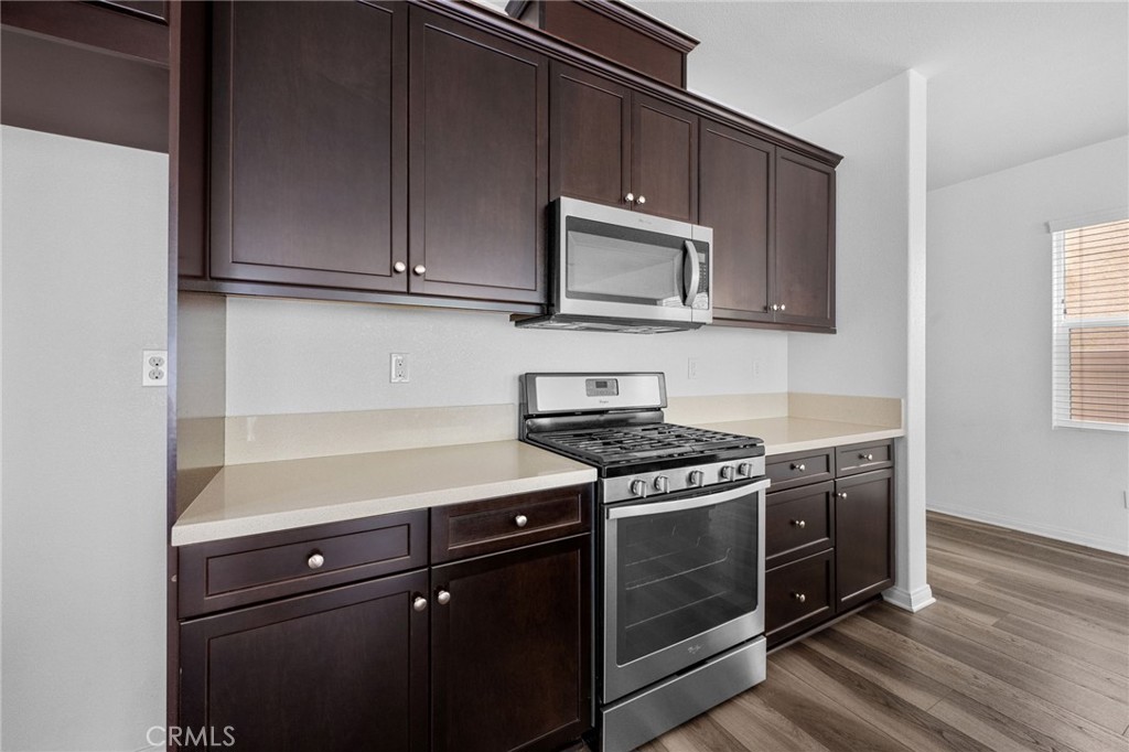893 Harvest Avenue Upland, CA 91786 - Photo 5 of 40 a kitchen with granite countertop cabinets stainless steel appliances and wooden floor