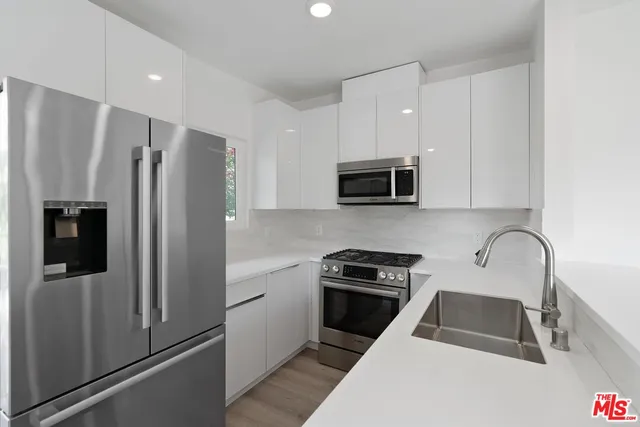 a kitchen with granite countertop a refrigerator and a sink