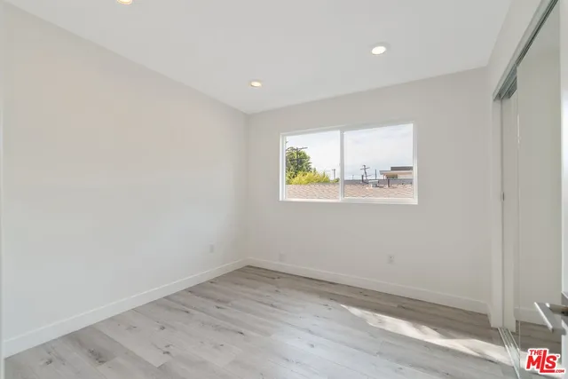 an empty room with wooden floor and window