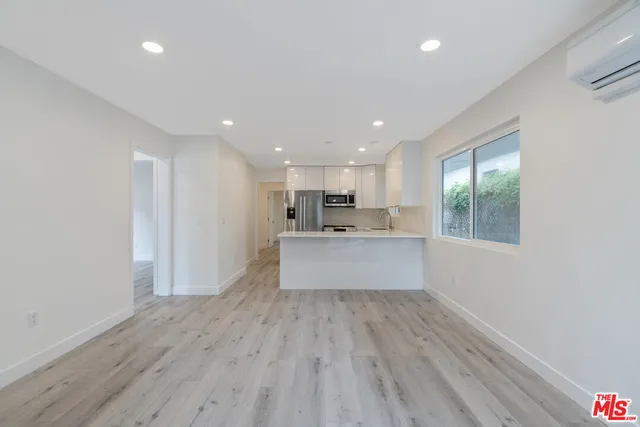 a large kitchen with kitchen island a sink dishwasher a stove and a refrigerator with wooden floor