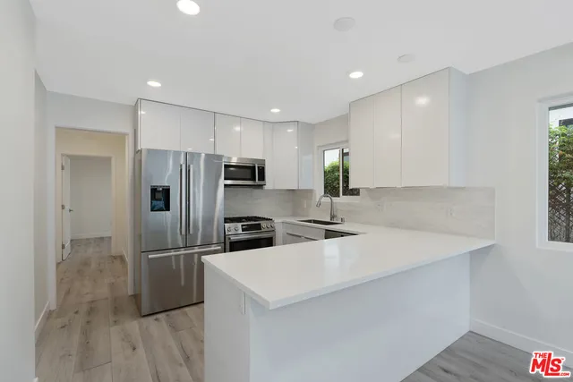 a kitchen with stainless steel appliances a refrigerator sink and microwave