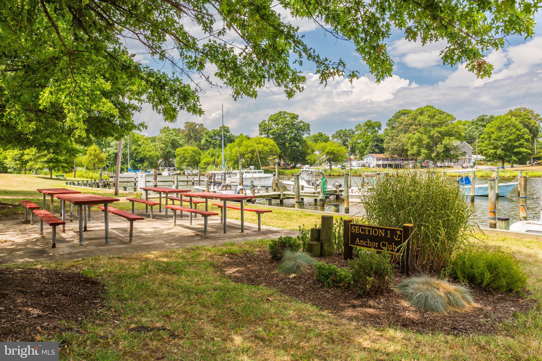 1502 Grange Road Edgewater, MD 21037 - Photo 42 of 43 a view of a lake with a bench and trees in the background