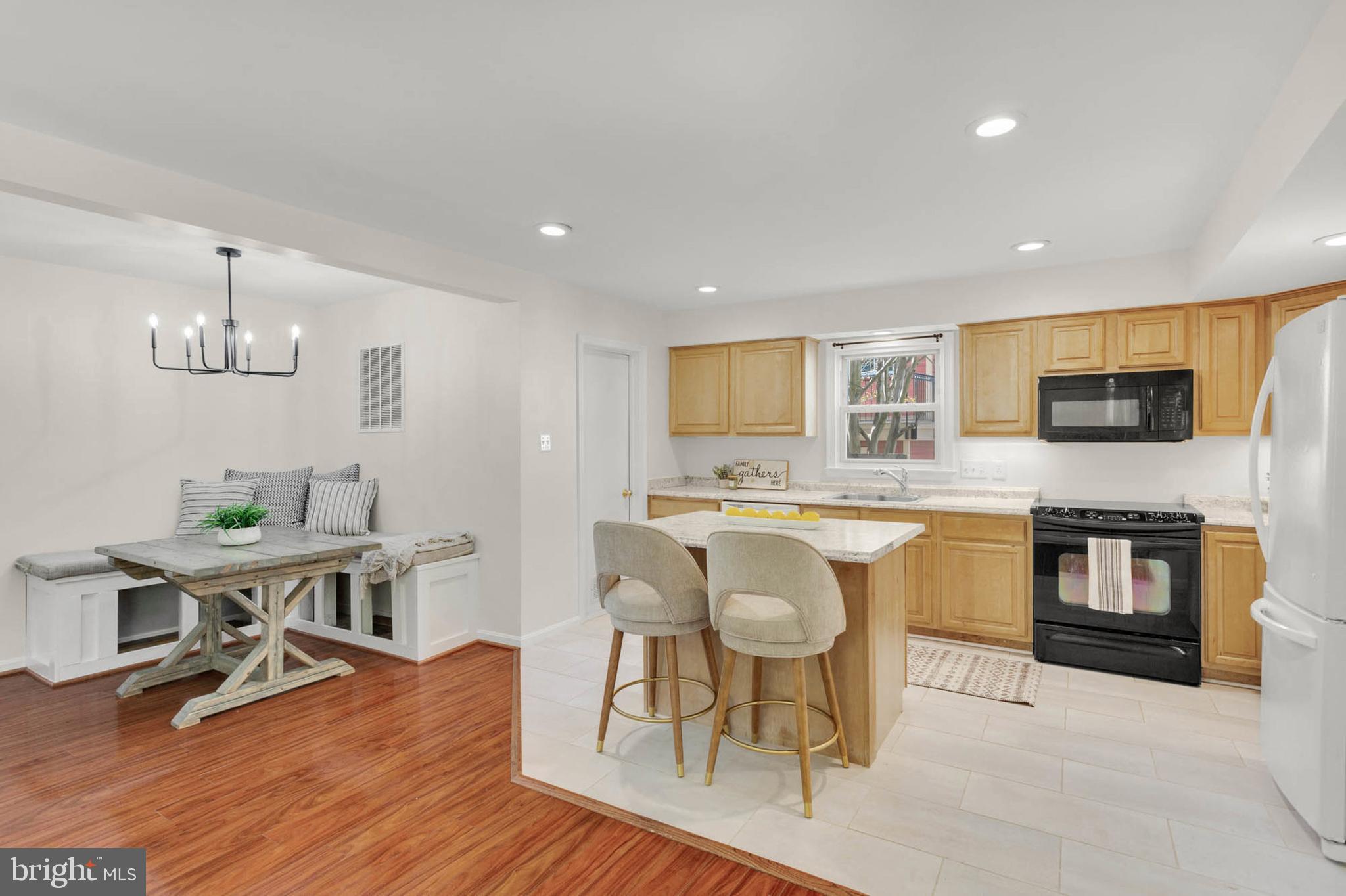 1502 Grange Road Edgewater, MD 21037 - Photo 10 of 43 a kitchen with stainless steel appliances granite countertop a stove top oven a sink dishwasher a dining table and chairs with wooden floor