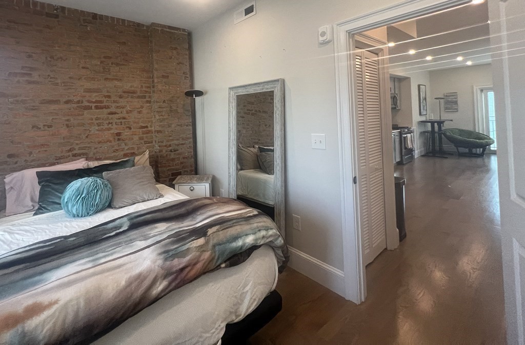 159 Bennington Street, Unit 2 Boston, MA 02128 - Photo 2 of 20 a bedroom with a bed and a chandelier