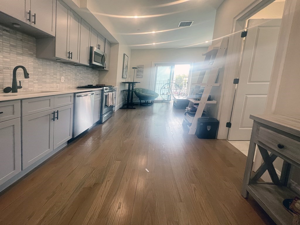 159 Bennington Street, Unit 2 Boston, MA 02128 - Photo 5 of 20 a kitchen with sink cabinets and wooden floor