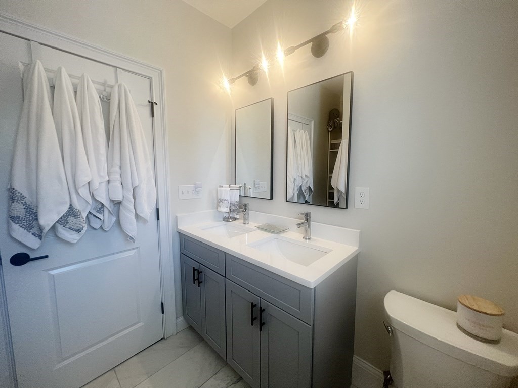 159 Bennington Street, Unit 2 Boston, MA 02128 - Photo 7 of 20 a bathroom with a toilet sink and mirror
